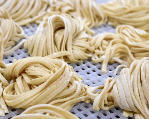 Uncooked pasta on a metal grate