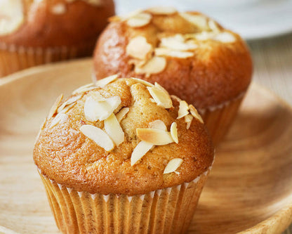 Muffins with almond flakes on a wooden plate